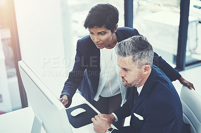 Buy stock photo Shot of a businesswoman and businessman using a computer together at work