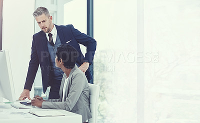 Buy stock photo Shot of a businesswoman and businessman using a computer together at work