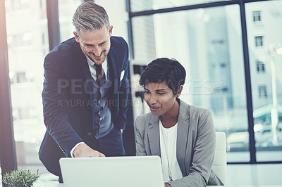 Buy stock photo Shot of a businesswoman and businessman using a laptop together at work