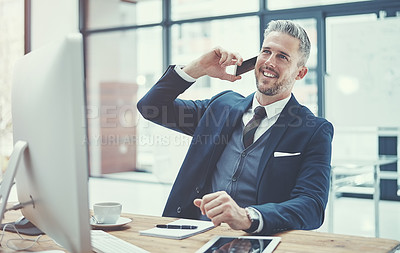 Buy stock photo Shot of a mature businessman using a cellphone at his desk in a modern office