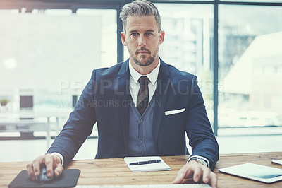 Buy stock photo Portrait of a mature businessman using a computer at his desk in a modern office