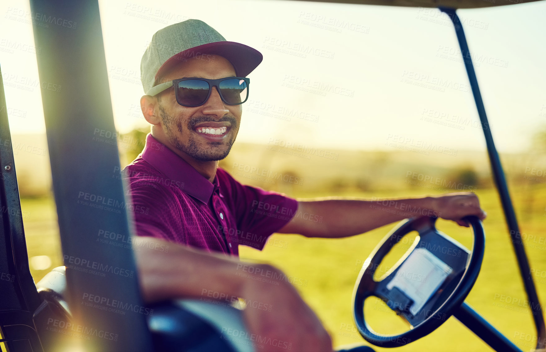 Buy stock photo Portrait of a happy young man driving a cart on a golf course