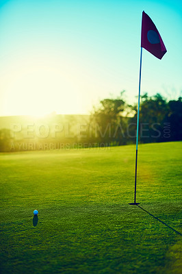 Buy stock photo Shot of a golf ball and flag on an empty course