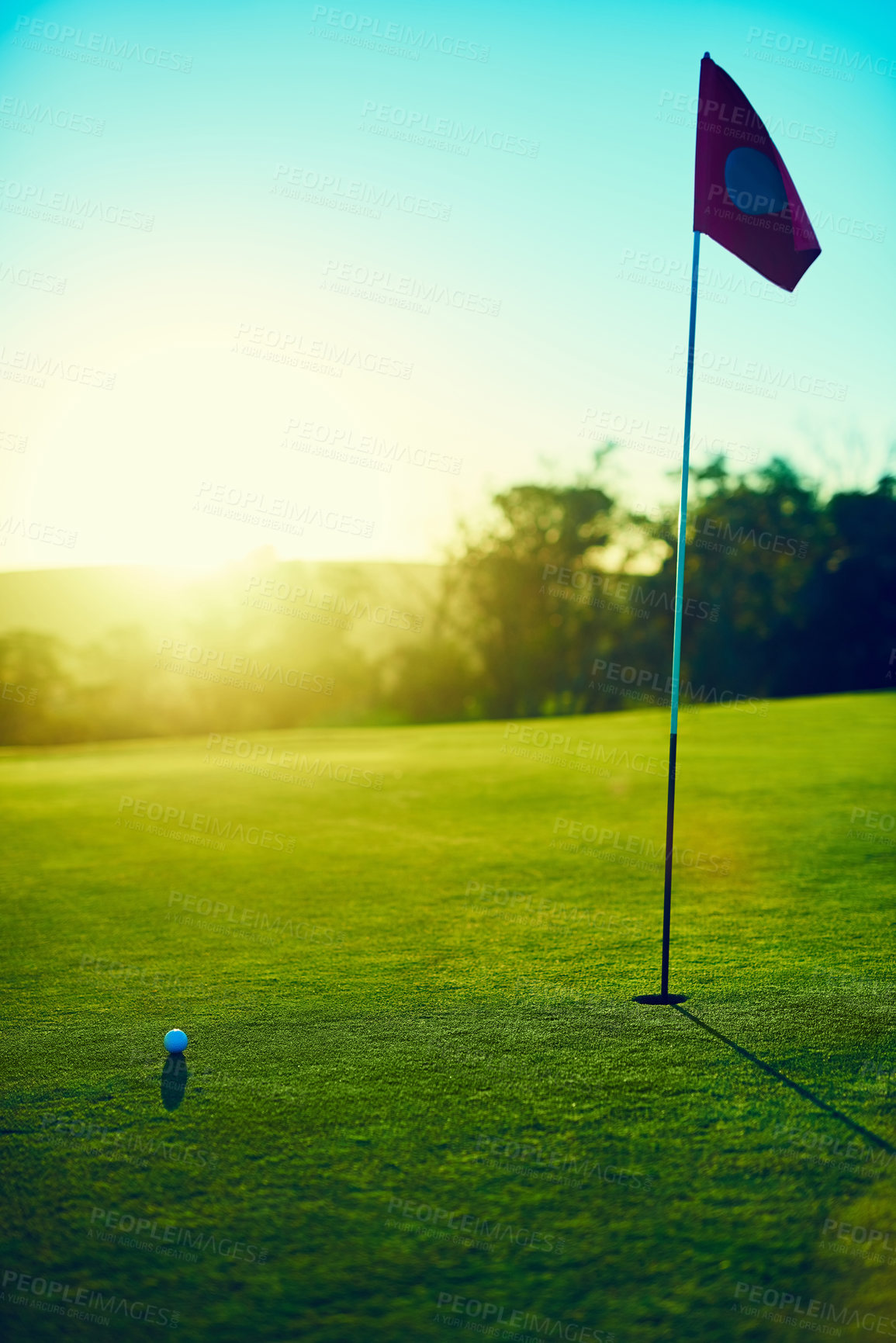 Buy stock photo Shot of a golf ball and flag on an empty course