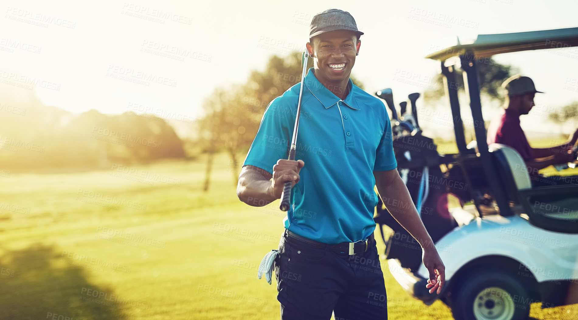 Buy stock photo Shot of a golfer holding his club with a buggy blurred in the background