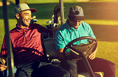 Buy stock photo Shot of two golfers riding in a cart on a golf course