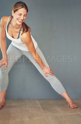 Buy stock photo Exercise, stretching and space with smile of woman in studio for health, wellness or yoga. Fitness, pilates or warm up and happy person on mockup with gray background for balance or holistic routine