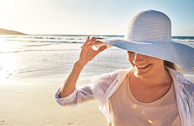 Buy stock photo Shot of a mature woman enjoying a day at the beach