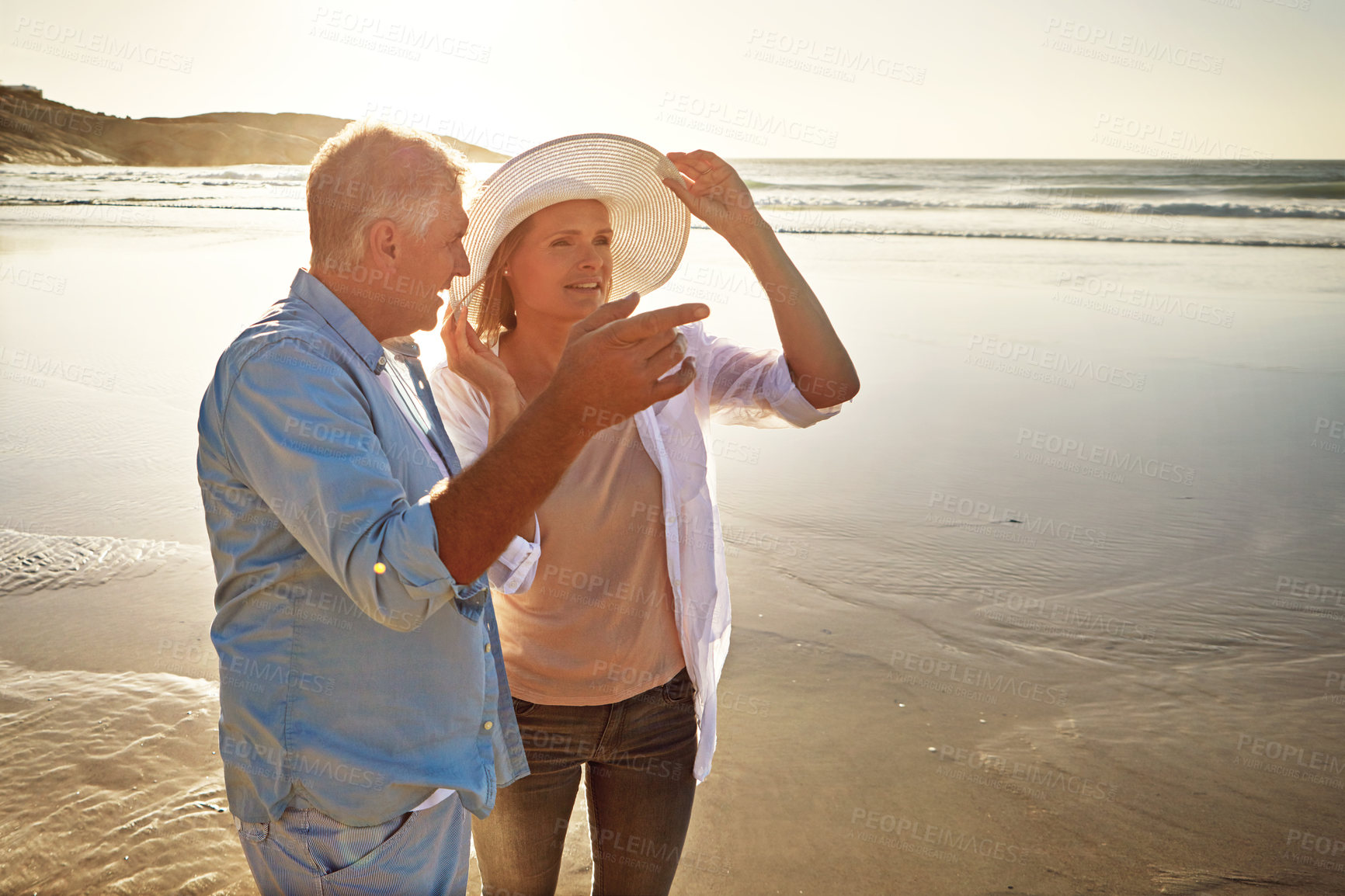 Buy stock photo Mature couple, pointing and beach with view in sunset for love, adventure or bonding together in nature. Man, woman or lovers with smile for outdoor tourism or summer holiday by water or ocean coast