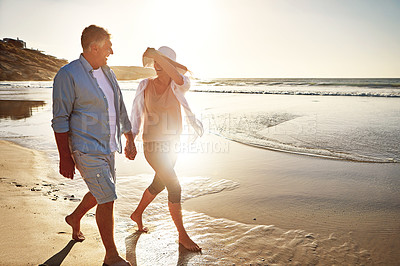 Buy stock photo Happy couple, walking and laugh on beach by ocean or coast for getaway, travel and vacation in Bali. Woman, man and holding hands for love or marriage anniversary on island at sunrise in Indonesia