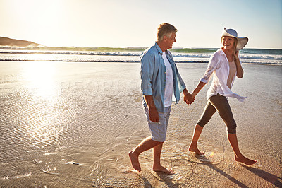 Buy stock photo Happy couple, walk and holding hands on beach for getaway on island or coast for vacation, travel and holiday. Woman, man and relationship for love or marriage anniversary by ocean at sunrise in Bali