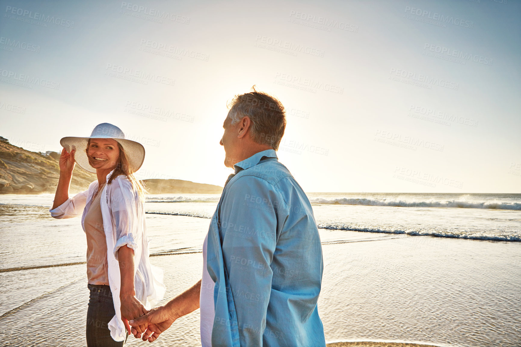 Buy stock photo Happy couple, walking and holding hands on beach on island or coast for getaway, travel and vacation in Bali. Woman, man and love for marriage anniversary by ocean at sunrise in Indonesia for holiday