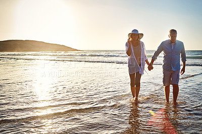 Buy stock photo Senior couple, walking and holding hands with beach sunset for love, embrace or bonding together in nature. Man, woman or lovers enjoying stroll on outdoor summer holiday by water, sea or ocean coast