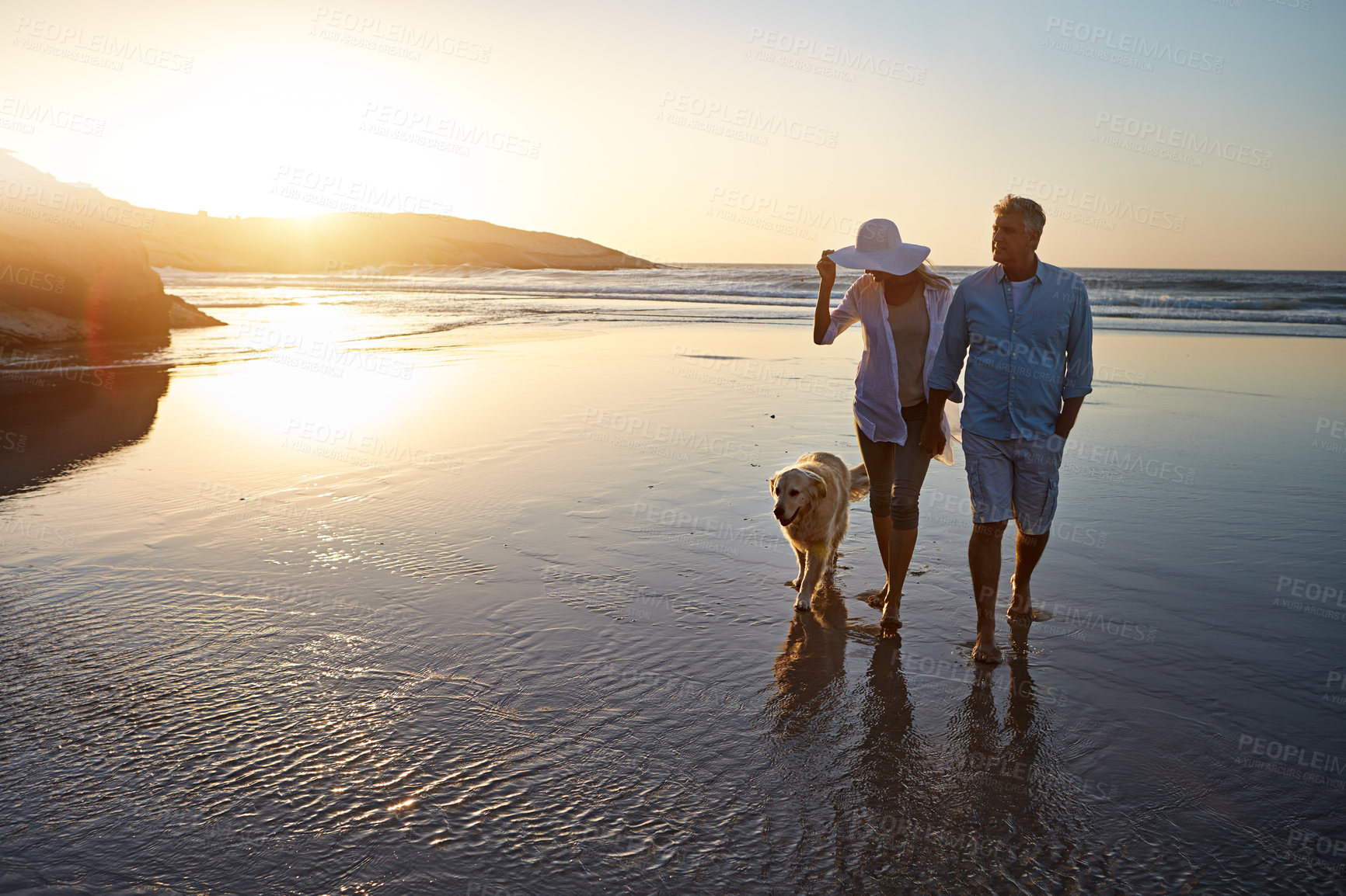 Buy stock photo Ocean, couple and dog with walking at sunset for trust, outdoor fun and holiday together. Waves, man and woman with furry pet at beach for summer travel, weekend adventure and vacation in Cancun