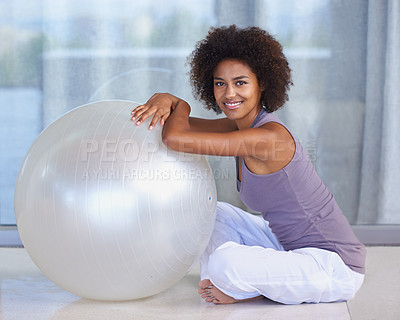 Buy stock photo Woman, portrait and exercise ball for fitness and wellness in studio or home for balance and health on the floor. Happy and young African person with workout, pilates and relax on ground for break