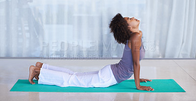 Buy stock photo Shot of an attractive young woman doing yoga on an exercise mat