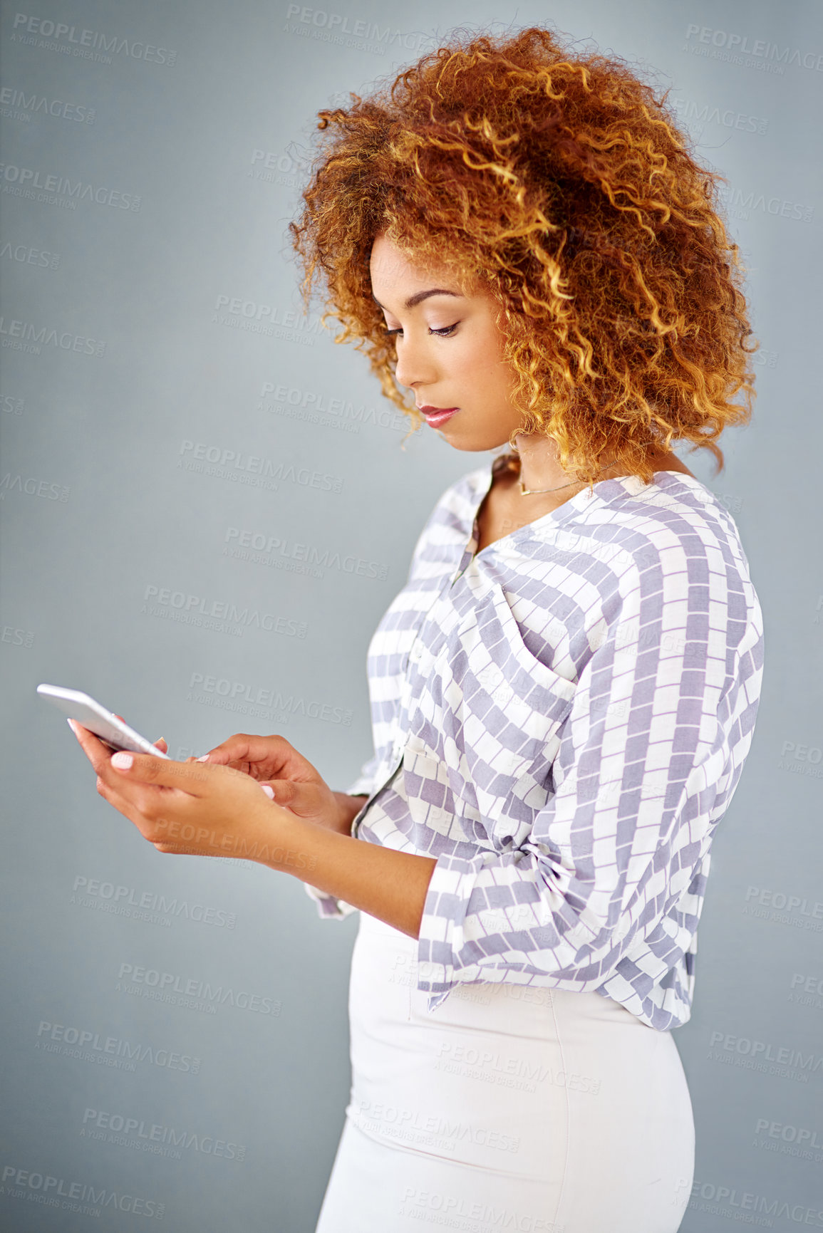 Buy stock photo Business woman, reading and browsing with phone in studio for online app or communication on a gray background. Young, female person or employee typing with mobile smartphone for texting or chatting