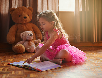 Buy stock photo Shot of a little girl reading a storybook