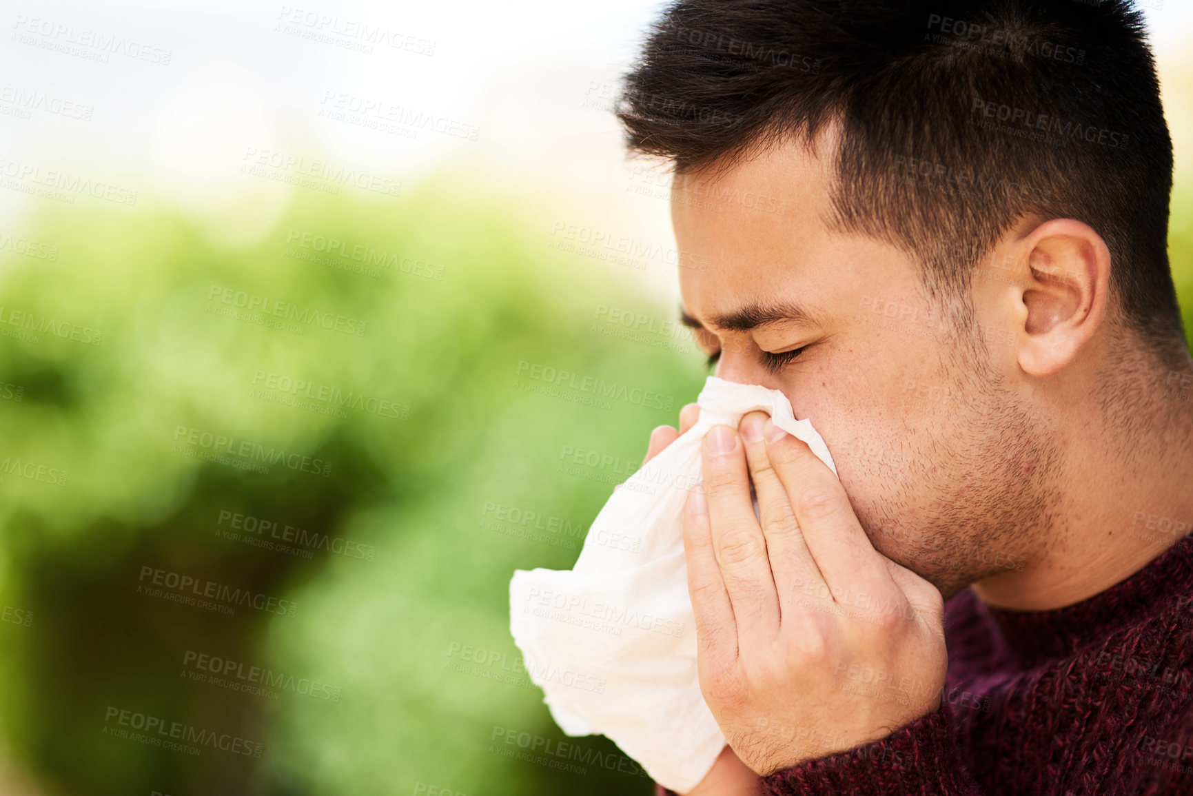 Buy stock photo Cropped shot of a young man blowing his nose outside