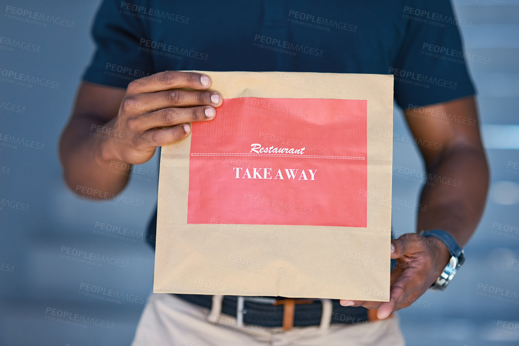 Buy stock photo Cropped shot of an unidentifiable delivery man holding a restaurant takeaway