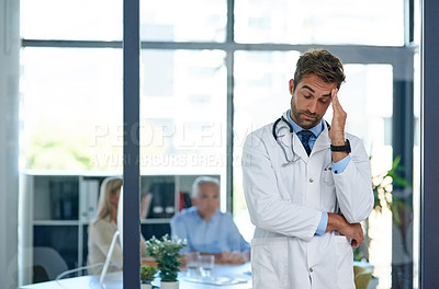 Buy stock photo Cropped shot of a doctor looking stressed out with two  patients sitting in the background