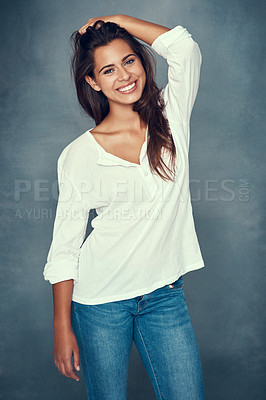 Buy stock photo Portrait of a beautiful young woman smiling against a gray background in studio