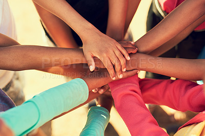 Buy stock photo Cropped shot of a group of children standing with their hands in a huddle outside