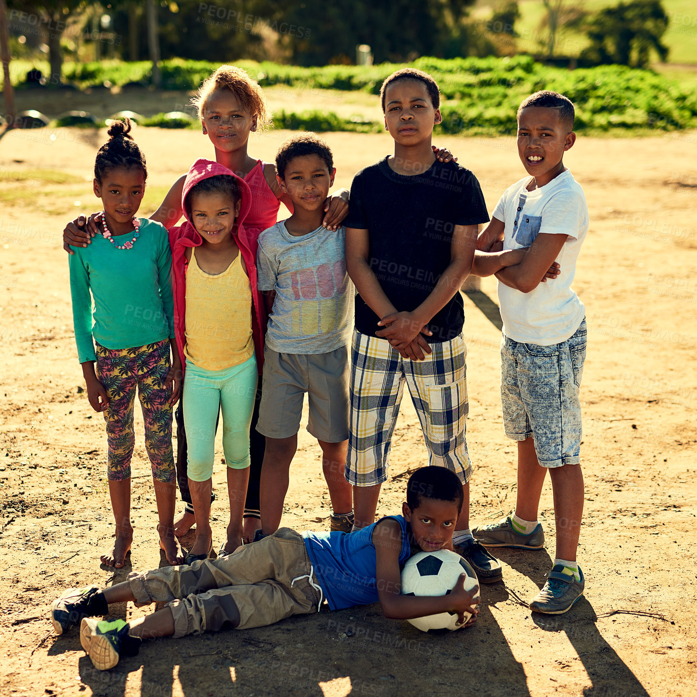 Buy stock photo Portrait of a group of children standing together with a soccer ball outside