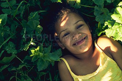 Buy stock photo Portrait of a smiling girl lying on the grass outside