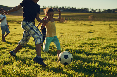 Buy stock photo Shot of a group of children playing soccer together in a field outside