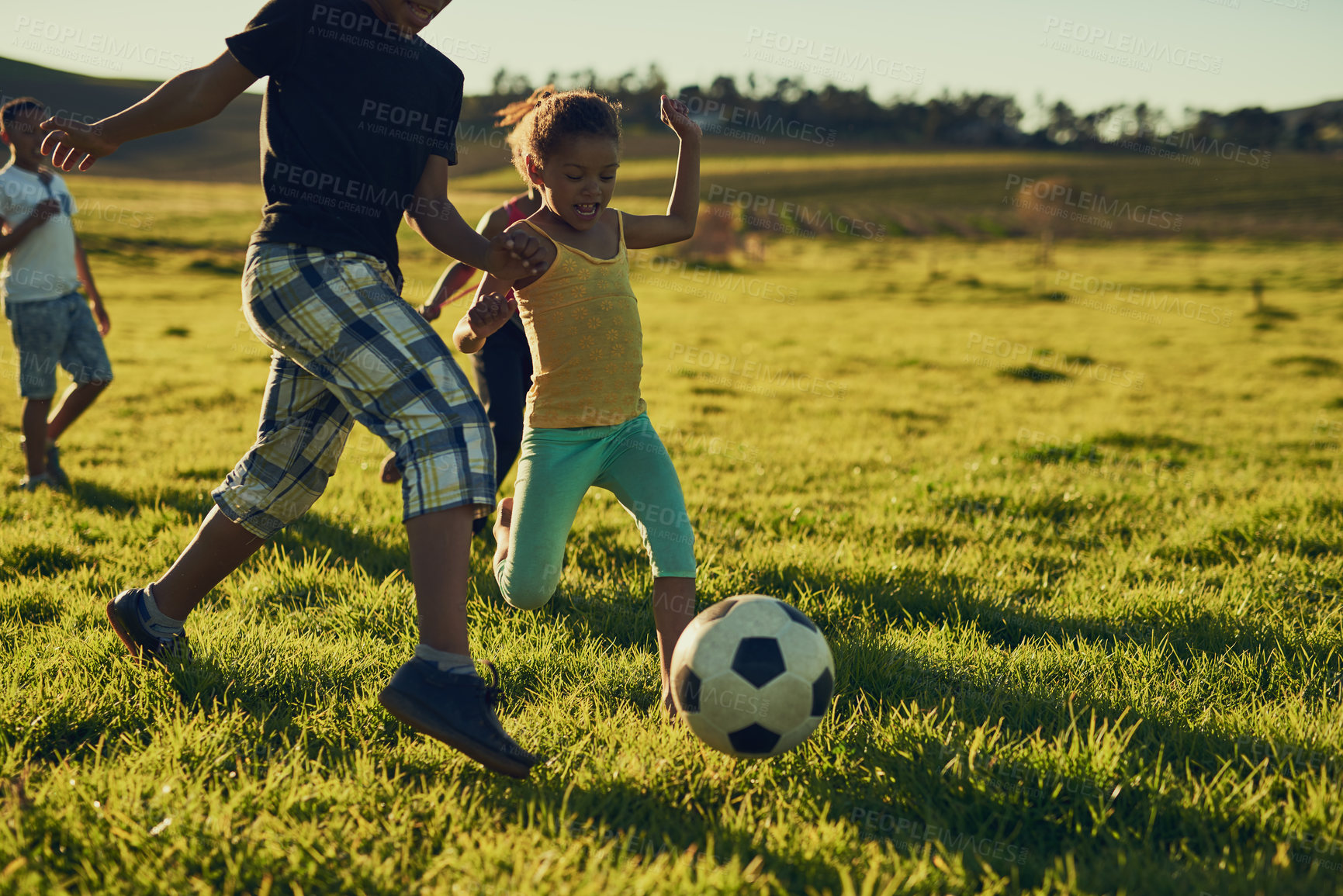 Buy stock photo Shot of a group of children playing soccer together in a field outside