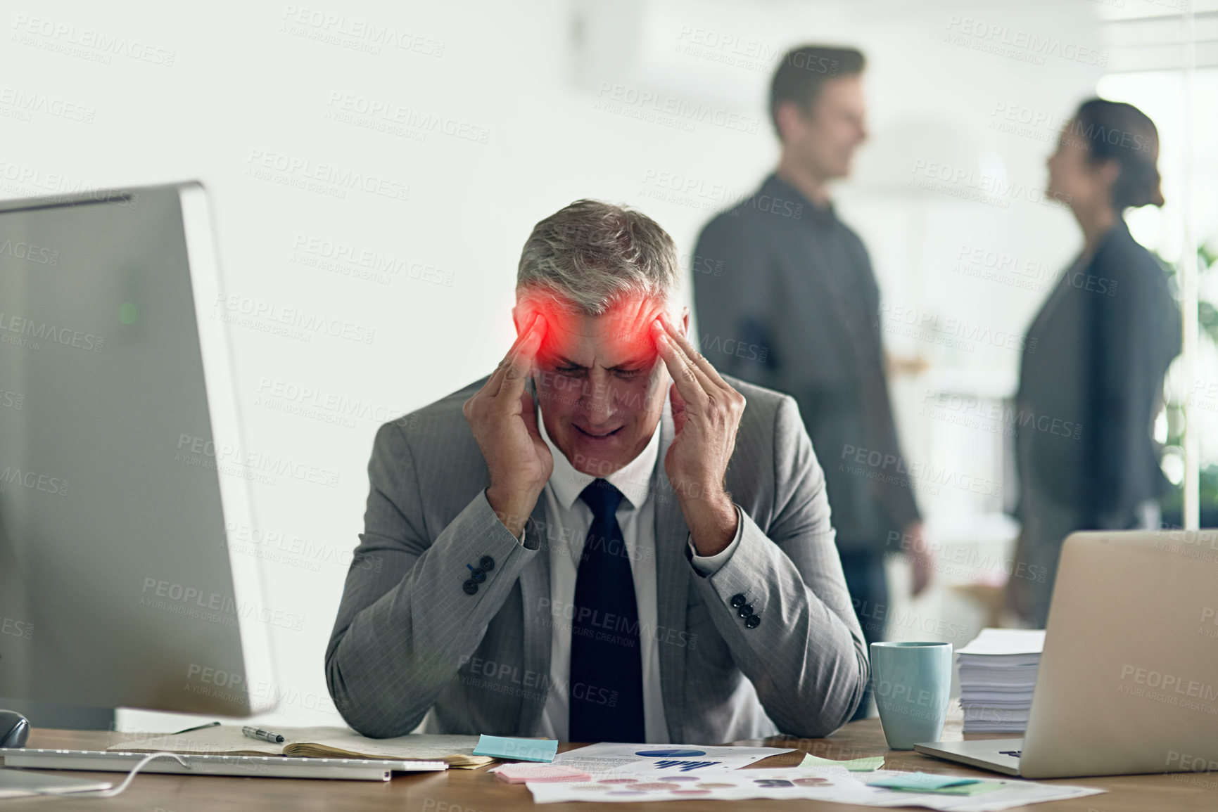 Buy stock photo Shot of a businessman with a headache holding his head while sitting at his desk