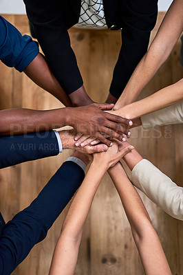 Buy stock photo High angle shot of a group of unidentifiable businesspeople piling their hands in unity in the office
