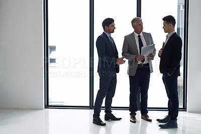 Buy stock photo Shot of a group of businessmen having a discussion in an office