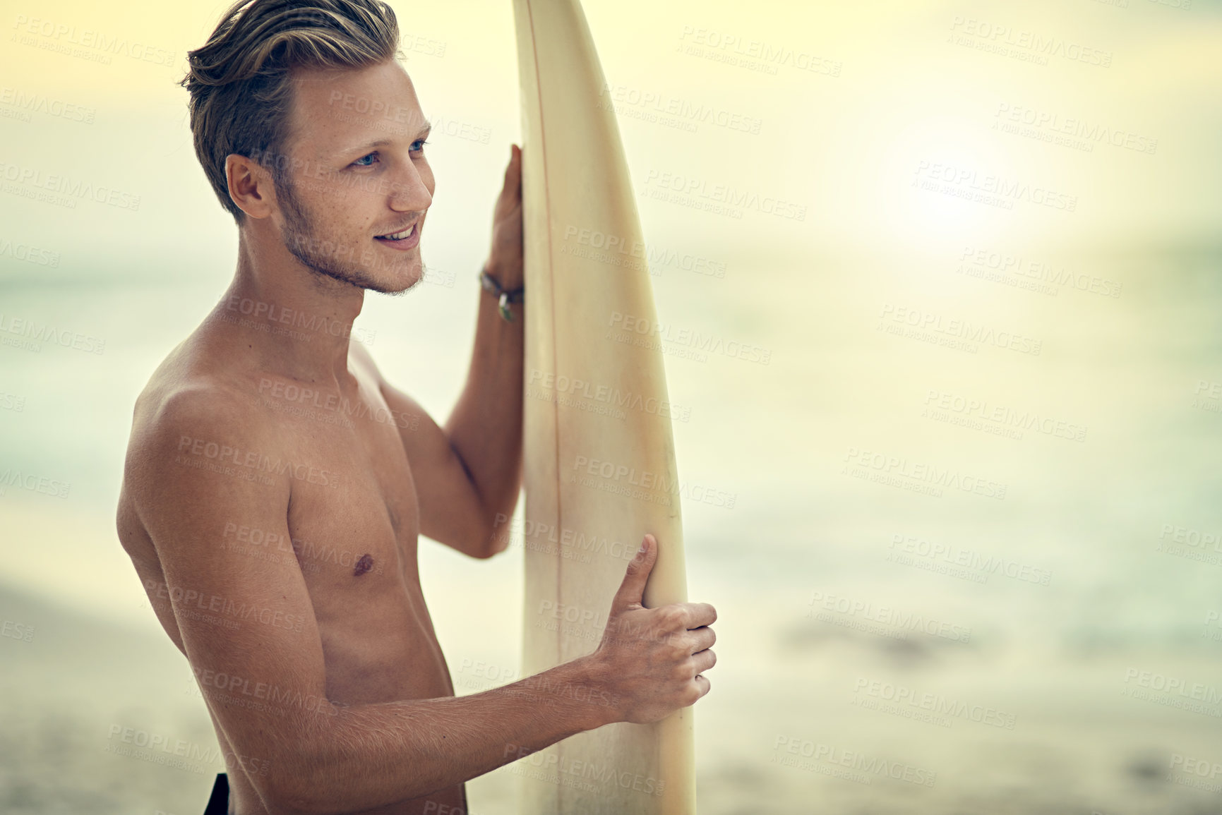 Buy stock photo Shot of a shirtless young surfer watching the waves while holding his surfboard at the beach