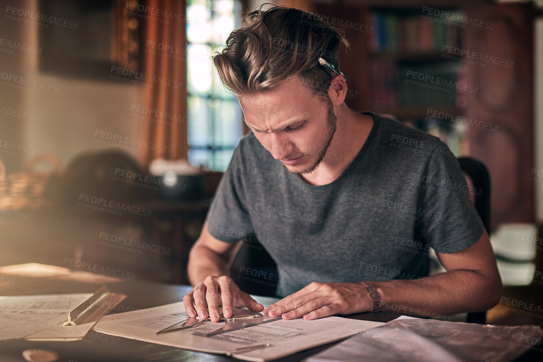 Buy stock photo Shot of a diligent young student doing a homework assignment at home