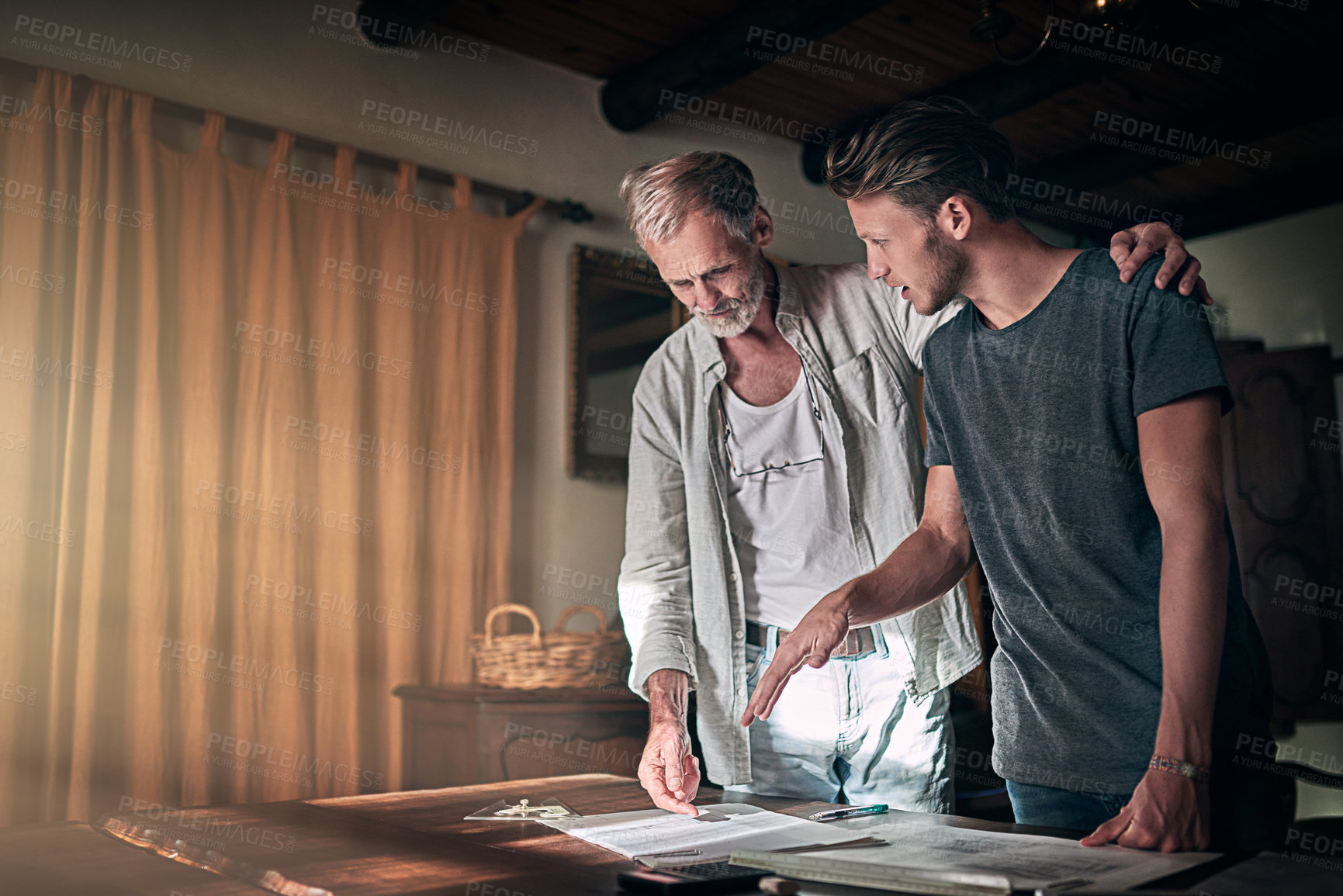 Buy stock photo Shot of a father and his son working on a design for their family business at home