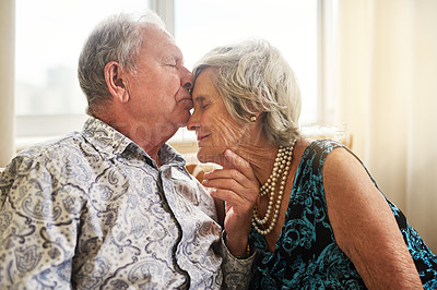 Buy stock photo Shot of a senior man tenderly kissing his wife’s forehead at home
