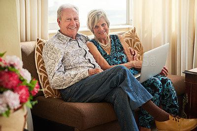 Buy stock photo Portrait of a senior couple using a laptop together on the sofa at home