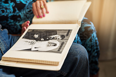 Buy stock photo Cropped shot of a senior couple looking through a photo album together at home