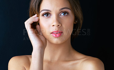 Buy stock photo Portrait of a beautiful young woman posing against a dark background