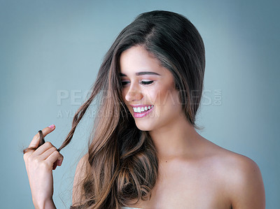 Buy stock photo Happy woman, hair and treatment with makeup for cosmetics, salon or spa day on a blue studio background. Attractive, young female person or model with smile in satisfaction for haircare or beauty