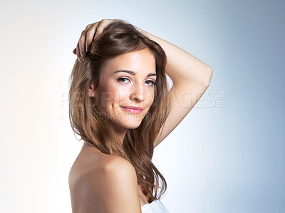 Buy stock photo Studio portrait of a beautiful young woman with her hand in her hair