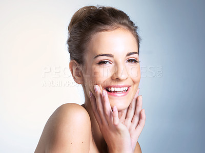 Buy stock photo Studio portrait of a beautiful young woman smiling with her hands on her chin