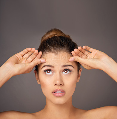 Buy stock photo Stress, touching and a woman with face wrinkles isolated on a dark background in a studio. Concern, anxiety and a young girl frustrated with skincare, filler and a facial beauty cosmetics mistake