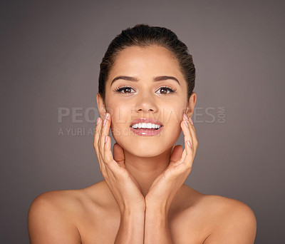 Buy stock photo Studio portrait of a beautiful young woman feeling her skin against a gray background