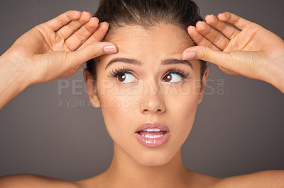 Buy stock photo Stress, beauty and a woman with face wrinkles isolated on a dark background in a studio. Concern, worry and a young girl frustrated with skincare, filler and a facial botox cosmetics mistake