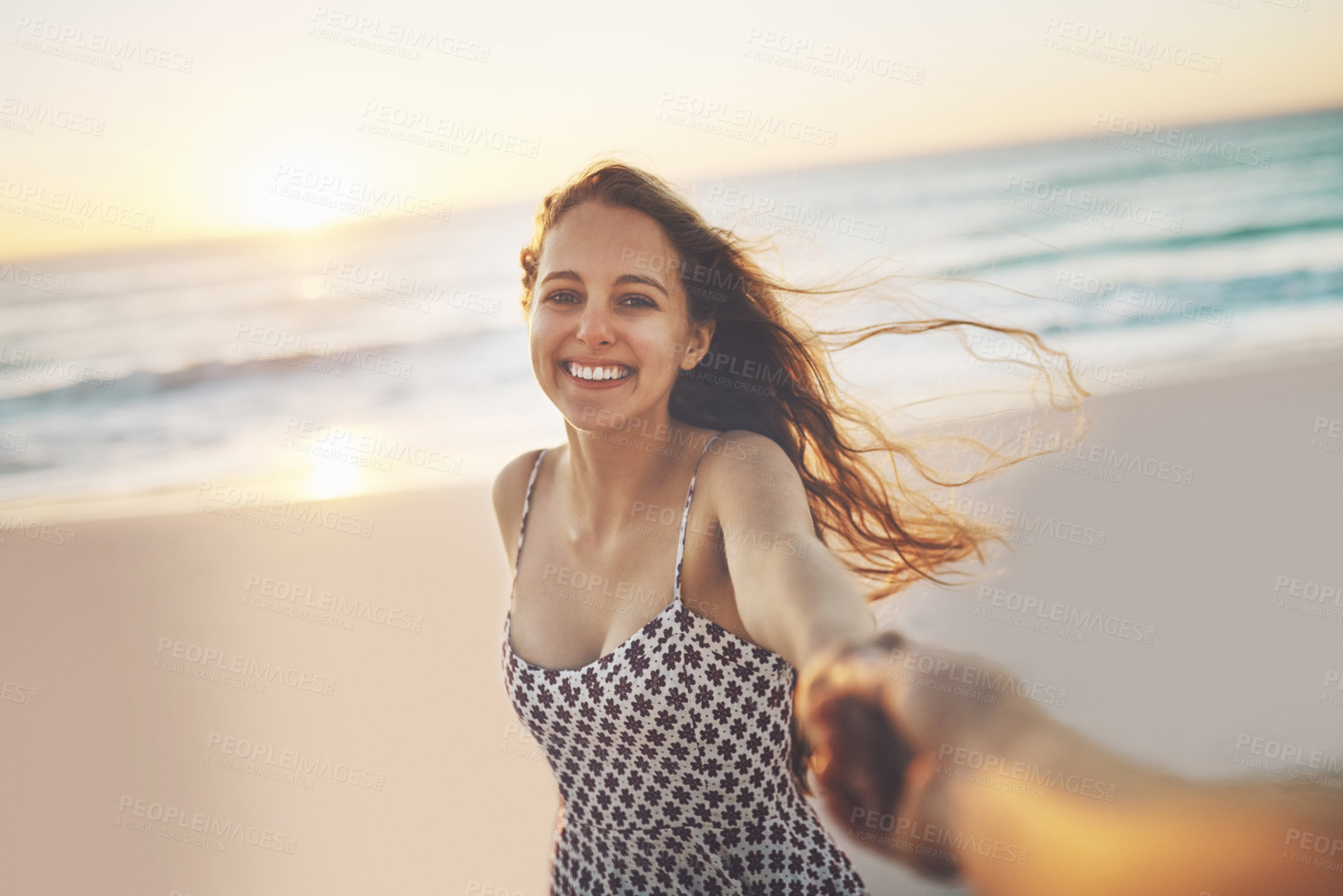 Buy stock photo Cropped shot of a young woman pulling someone's hand at the beach