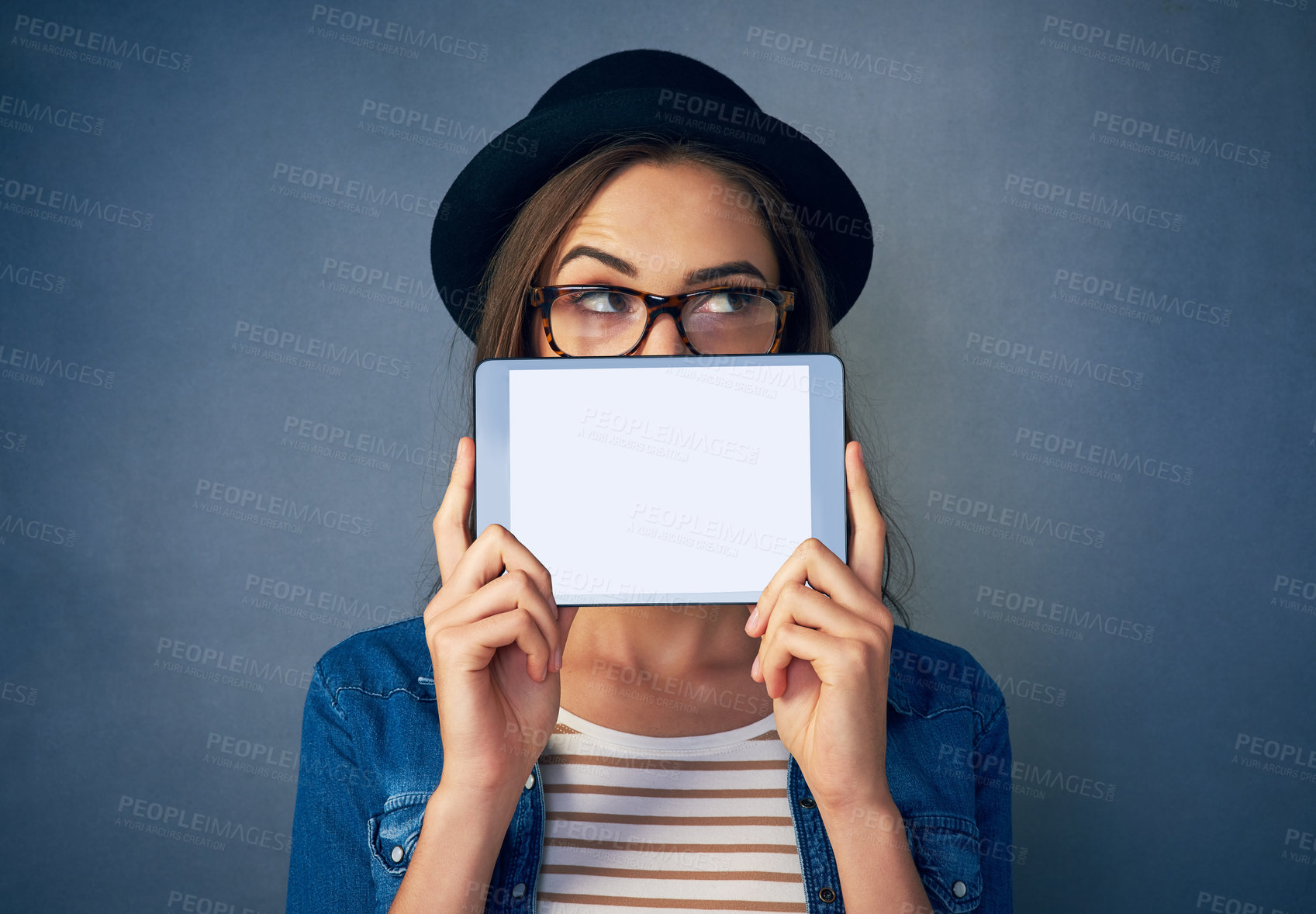 Buy stock photo Face, tablet and space with a fashion woman in studio on a blue background for social media marketing. Idea, display and style with a young person holding an empty screen for advertising mockup
