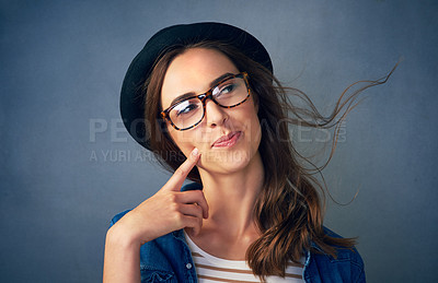 Buy stock photo Shot of a quirky young woman smiling against a gray background in studio